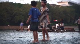 2个男孩提鞋淌水过河实拍视频素材